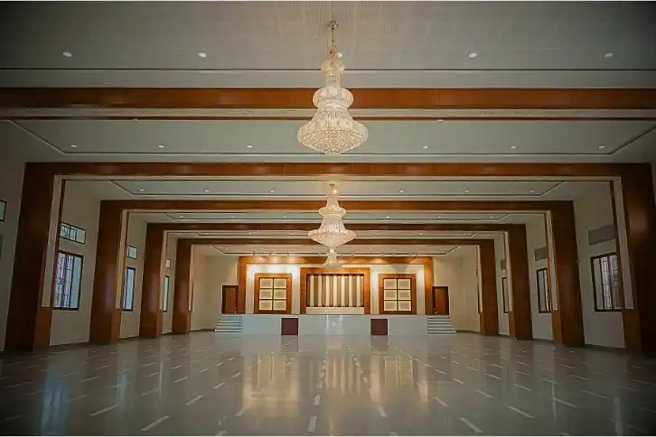 A long, elegant hallway adorned with chandeliers hanging from a beautifully designed ceiling.