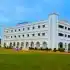 A large white building stands prominently against a lush green lawn, creating a serene and inviting atmosphere.