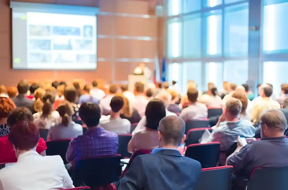 A diverse group of individuals engaged in discussion within a spacious conference room setting.