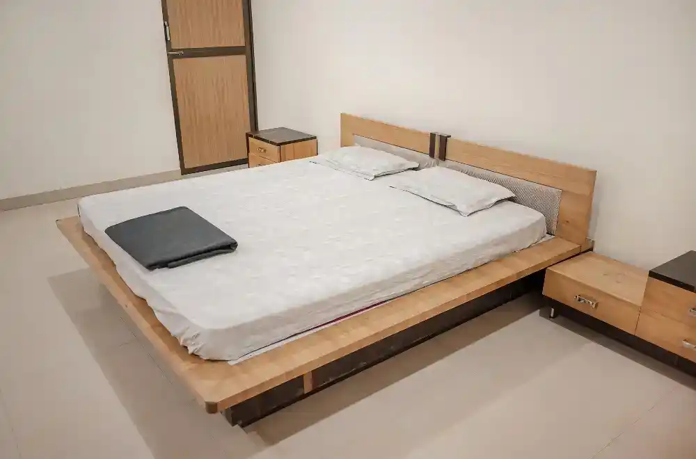 A neatly made bed featuring white sheets and a sturdy wooden frame, creating a serene and inviting atmosphere.