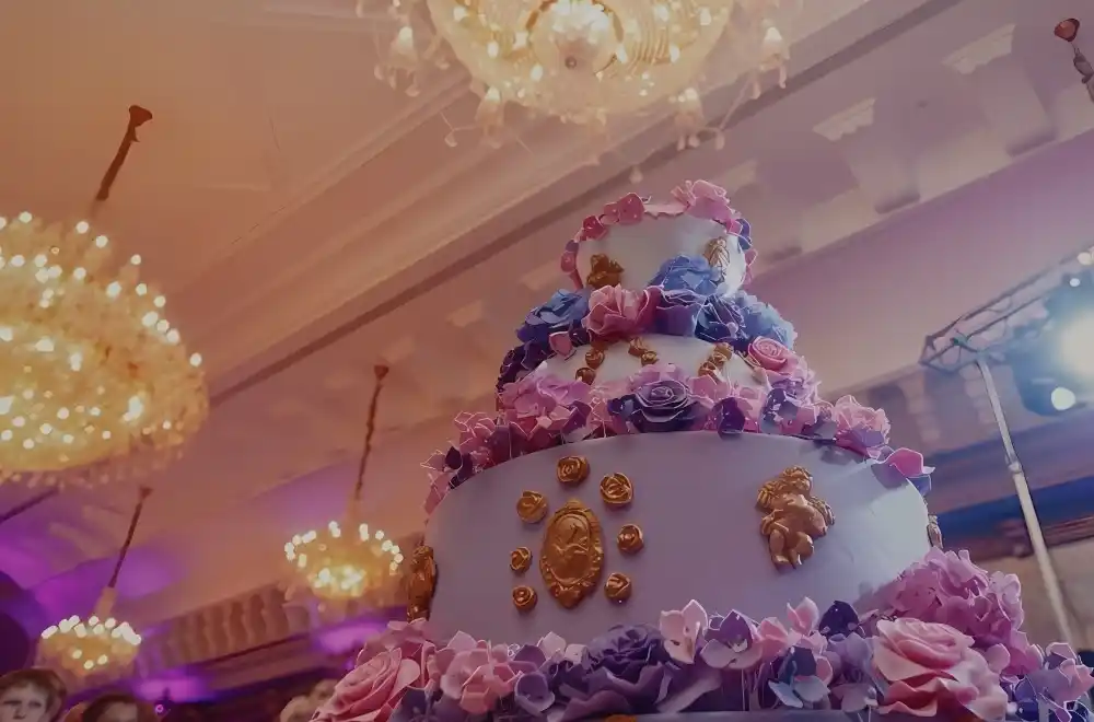 A beautifully designed wedding cake adorned with elegant purple and gold decorations, showcasing a sophisticated celebration.